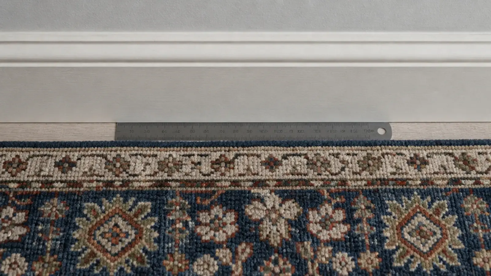 rug edge sitting too close to a wall leaving a narrow floor strip