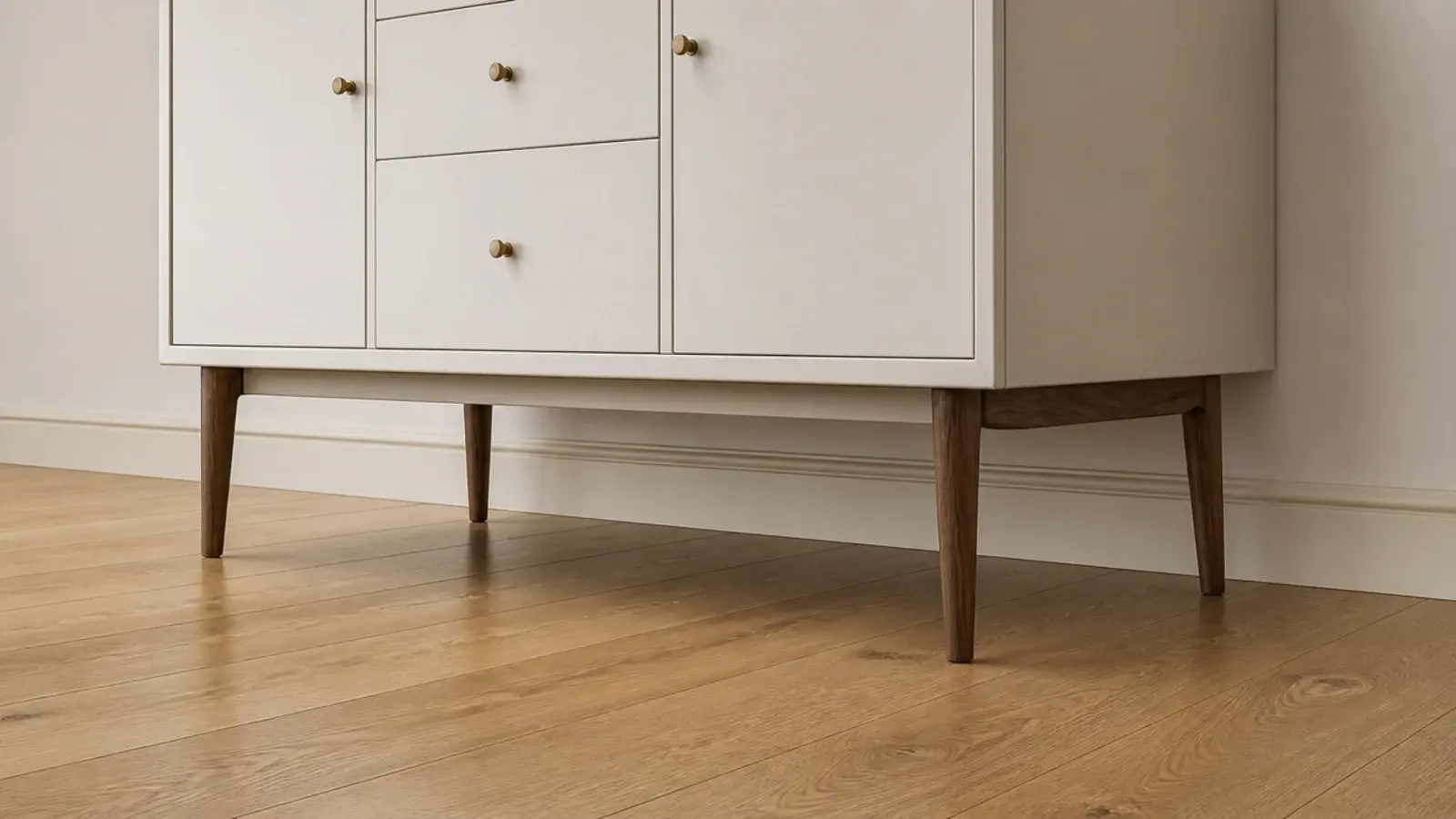 modern shoe cabinet raised on slim tapered walnut legs above oak flooring
