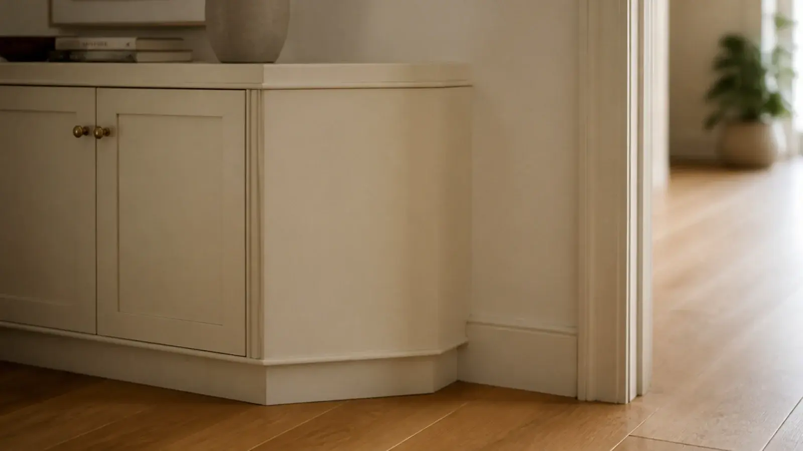 slim shoe cabinet with a chamfered end panel easing a narrow hallway turn