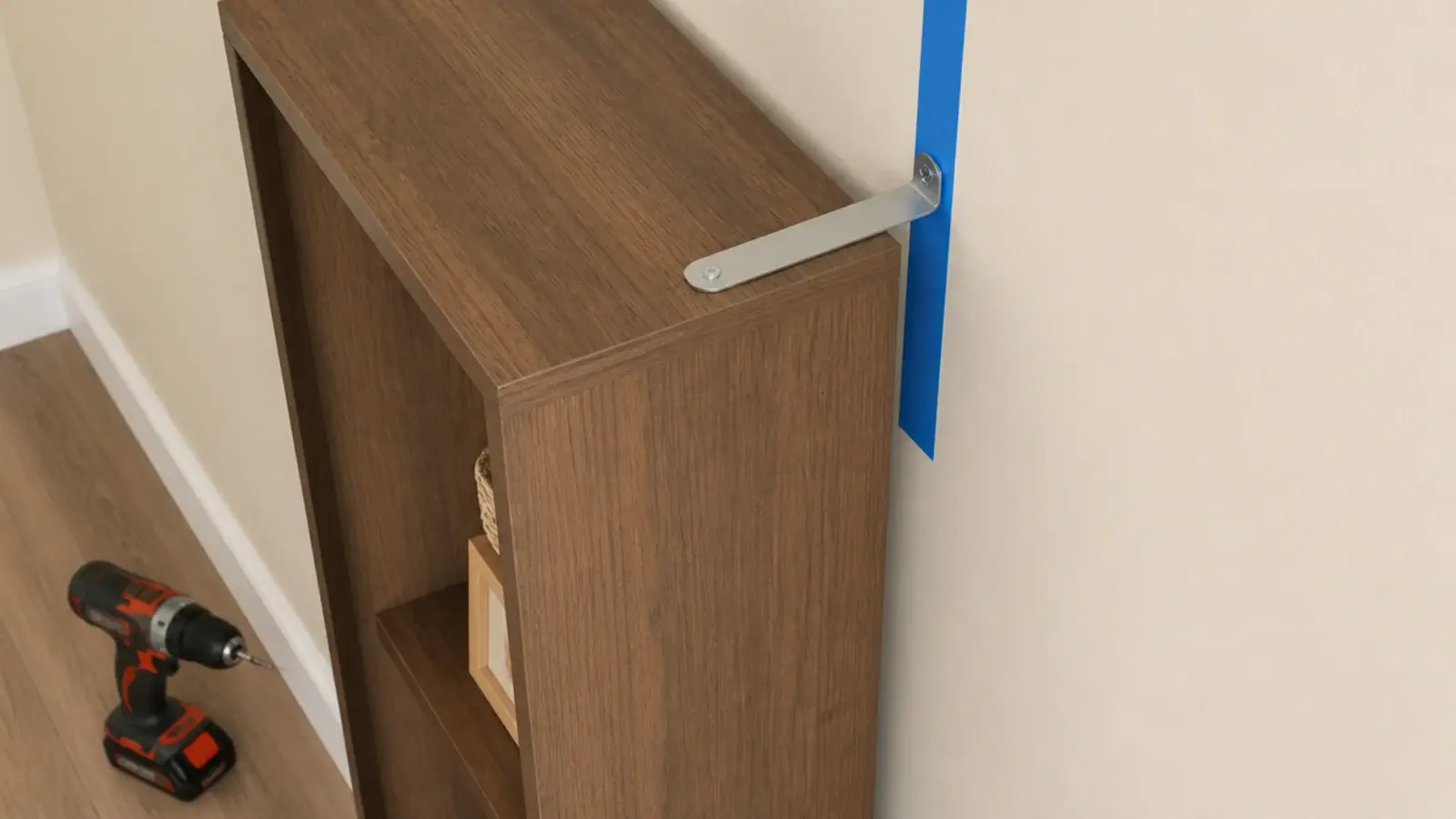 anti tip strap securing a tall slim shoe cabinet to a hallway wall