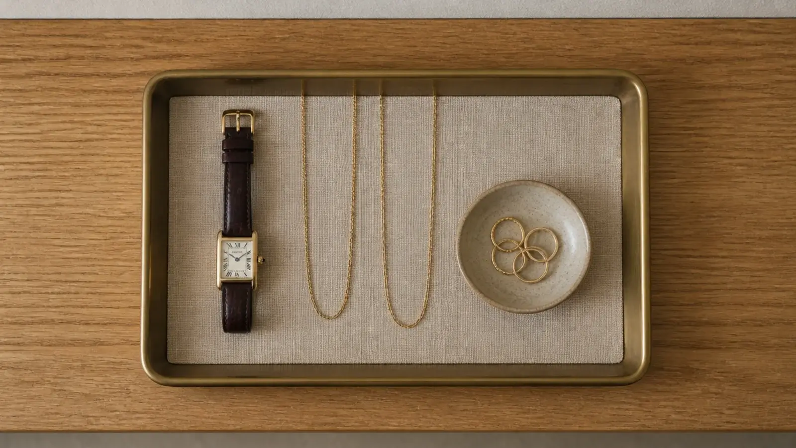 single linen lined tray holding jewelry on a minimalist closet shelf
