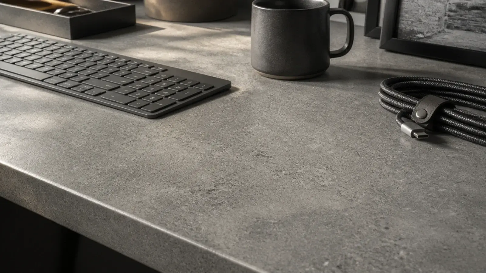 grey concrete effect laminate desk surface with a keyboard and mug