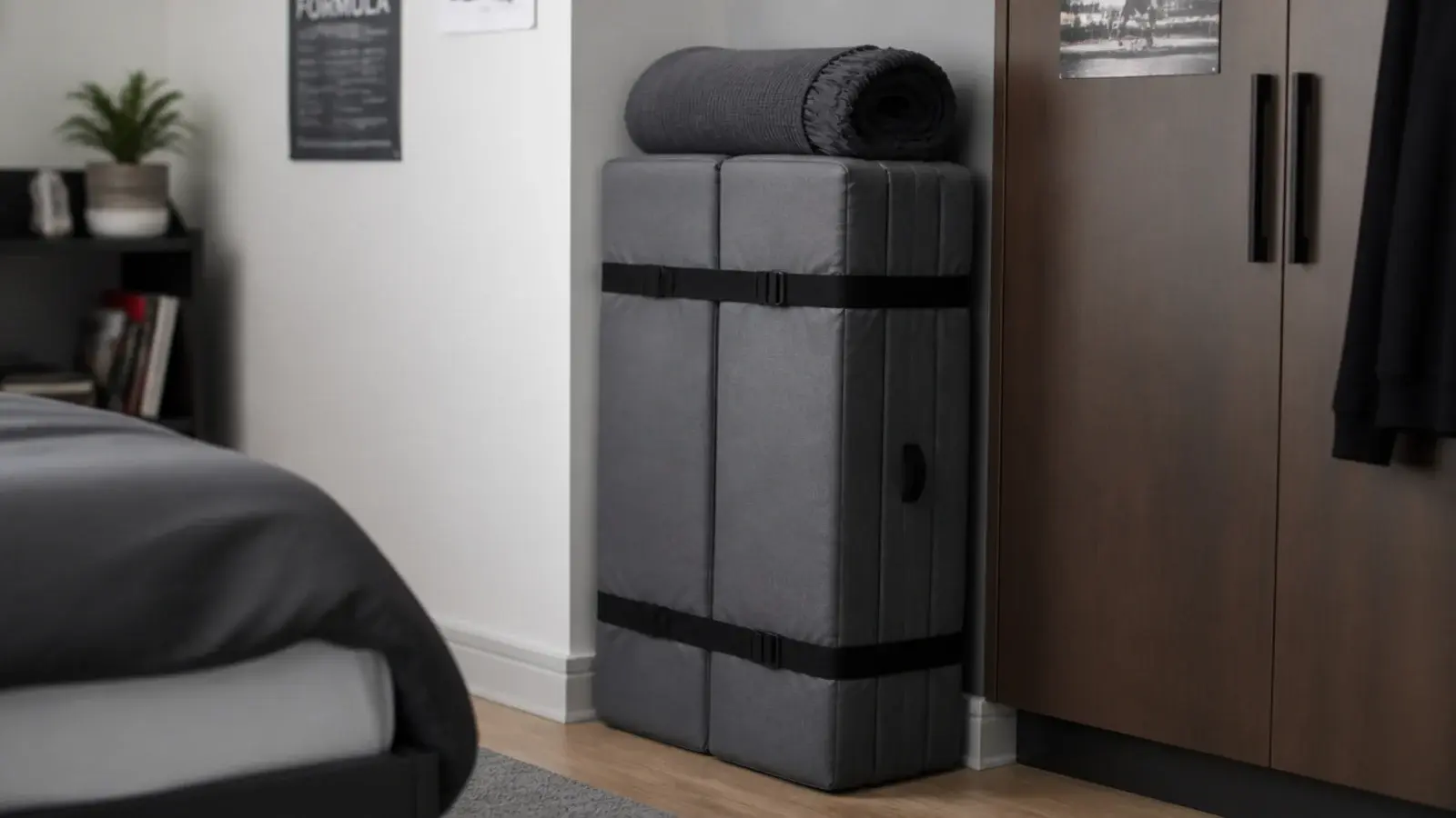 folded guest mattress stored upright beside a wardrobe in a bedroom