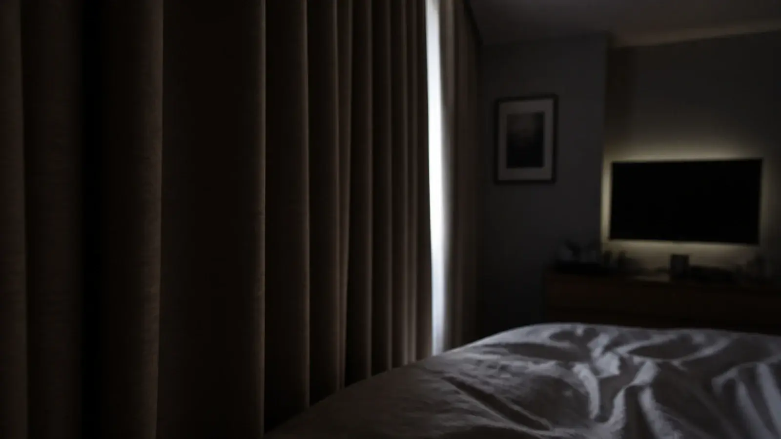 heavy blackout curtains drawn across a bedroom window at midday