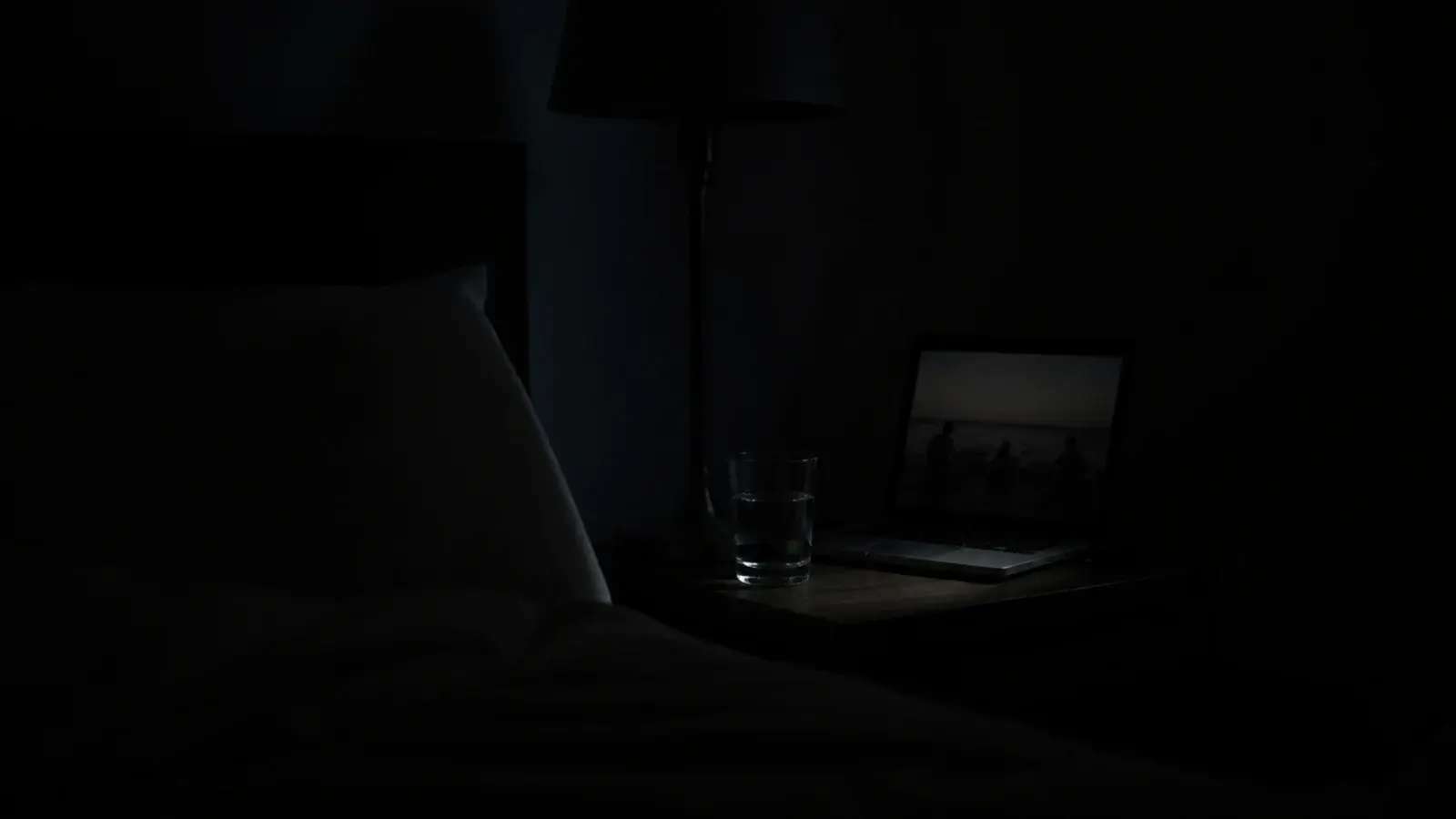 dimmed screen glowing softly in a dark bedroom late at night