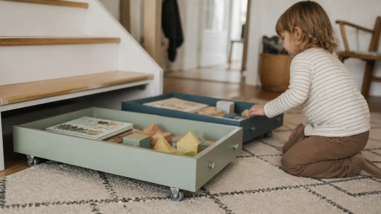 low toy drawers on castors pulled out onto a hallway rug