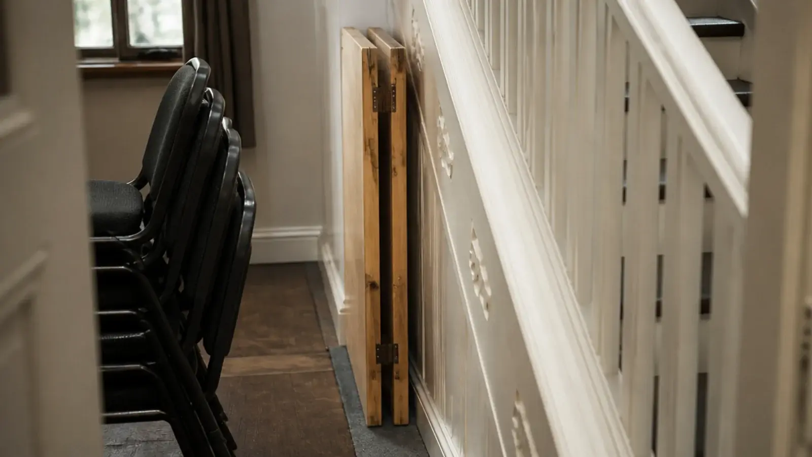 folding table stored on edge in a slim gap beside a staircase