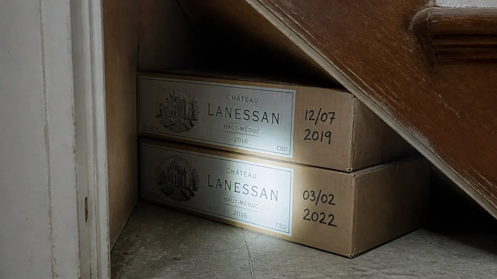 labelled cardboard wine cases pushed into the deepest stair corner