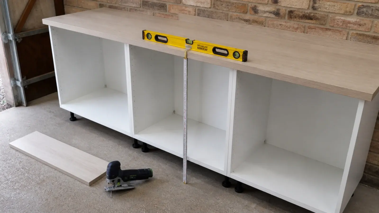 laminate worktop being levelled over new cabinets in a garage utility