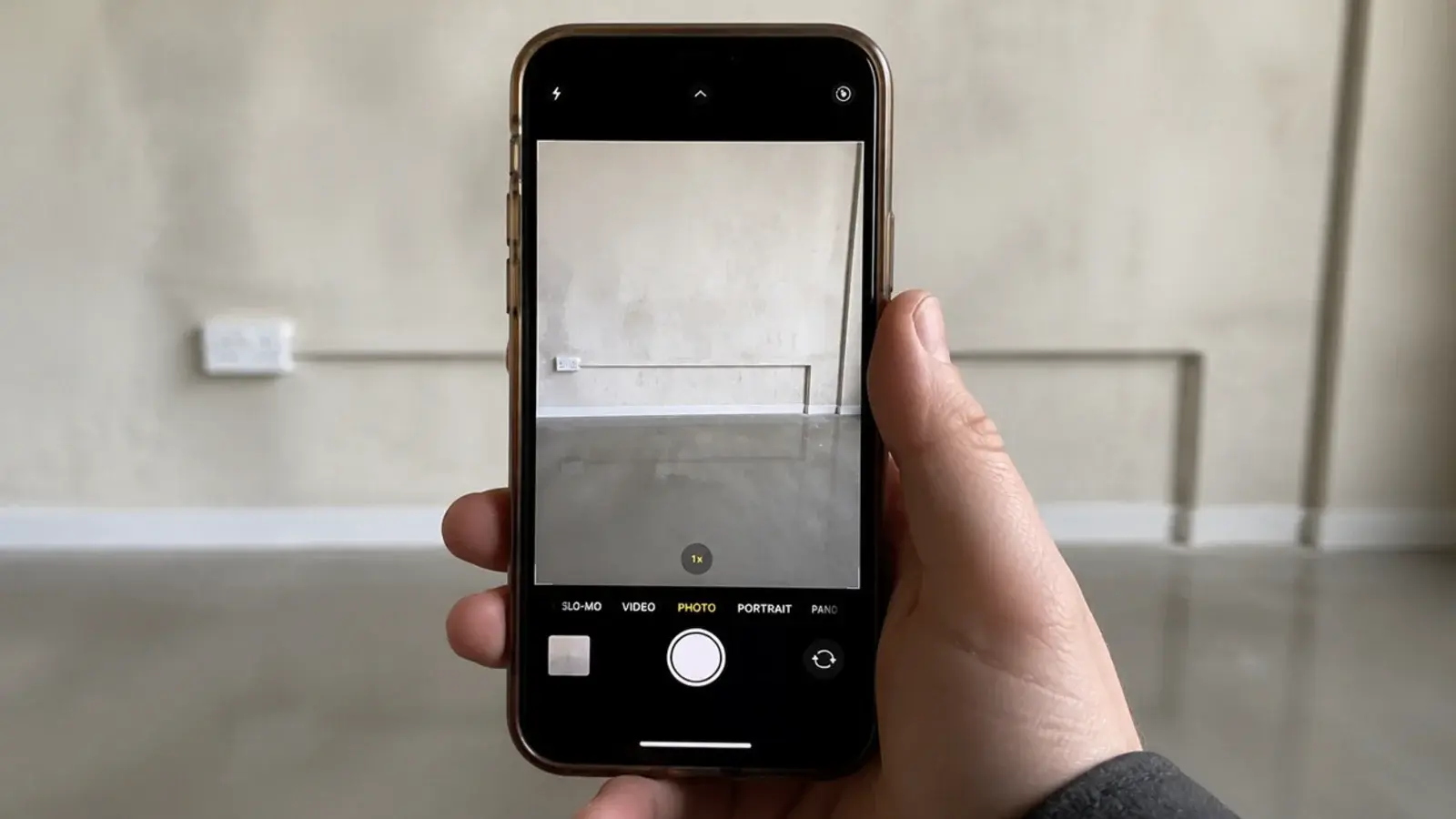 phone photographing a bare utility wall before any shelving goes up