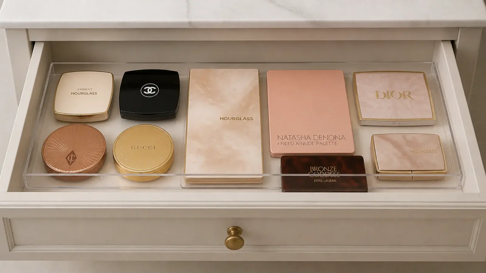 shallow acrylic tray sitting inside a vanity drawer holding flat compacts