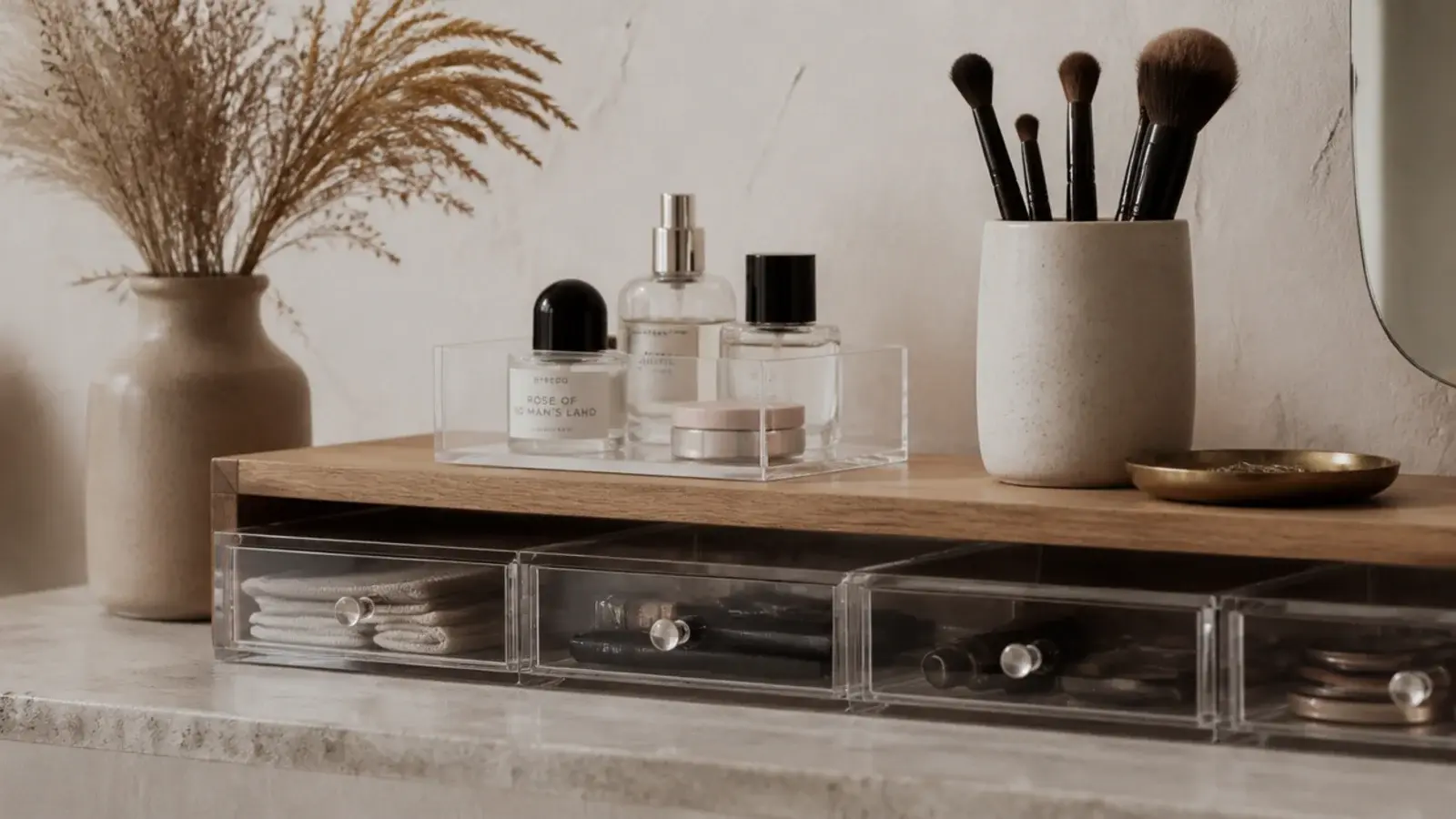 acrylic organizers softened by oak stoneware and brass on a vanity counter