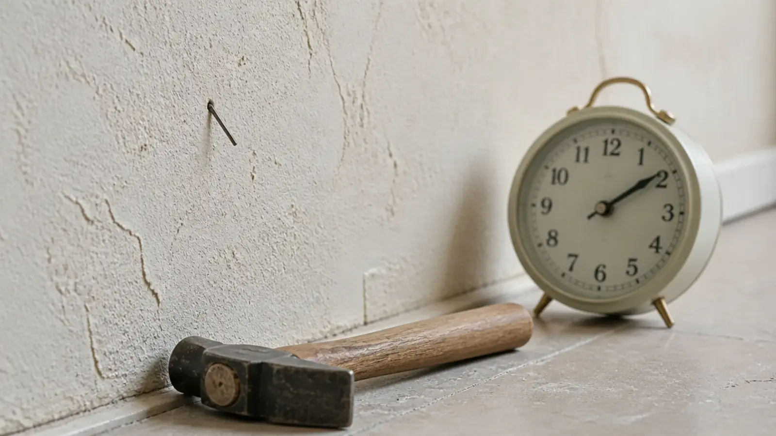 fine brad pin driven at an angle into plaster behind a clock
