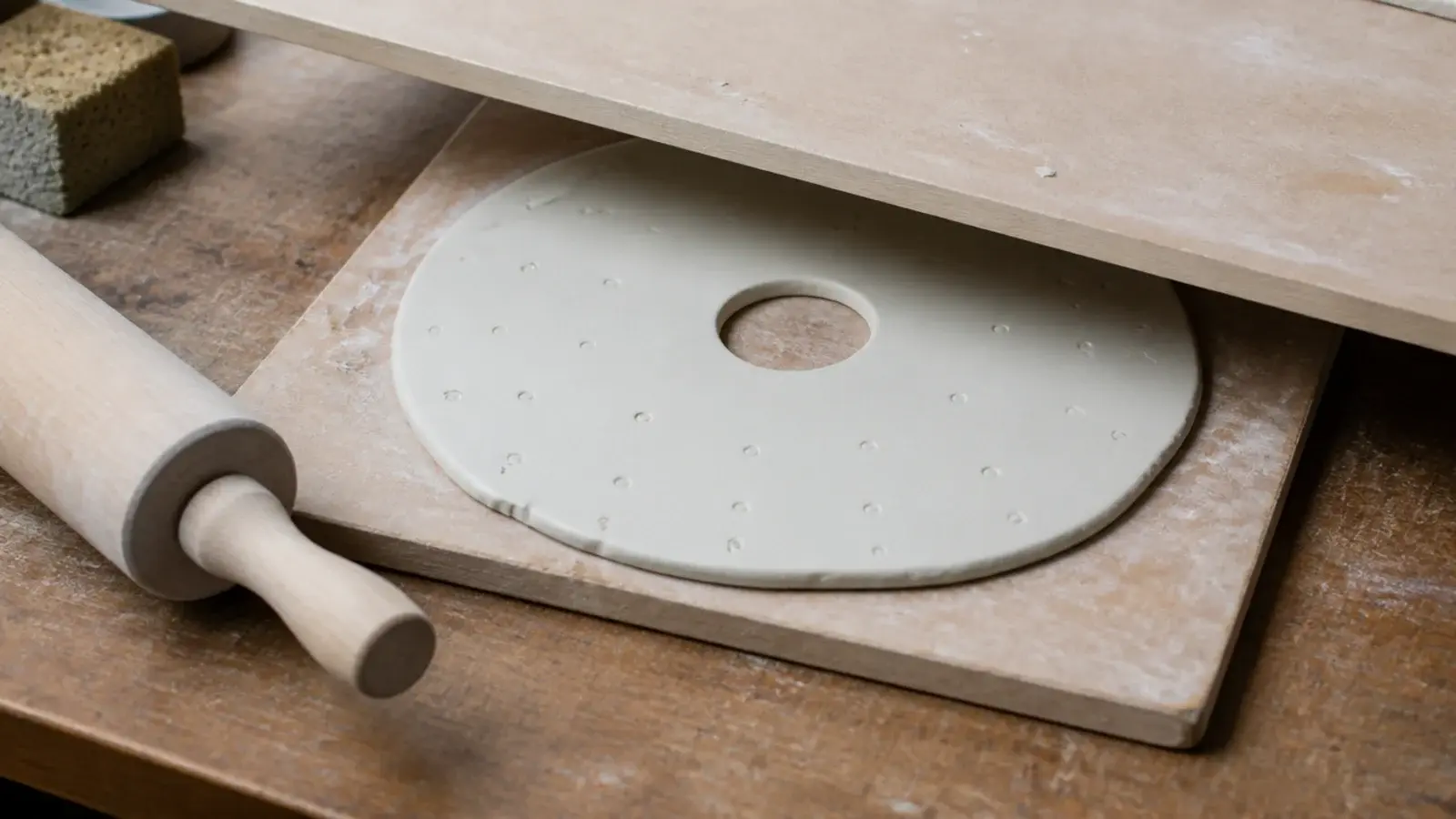 hand rolled air dry clay slab with pressed markers around the edge
