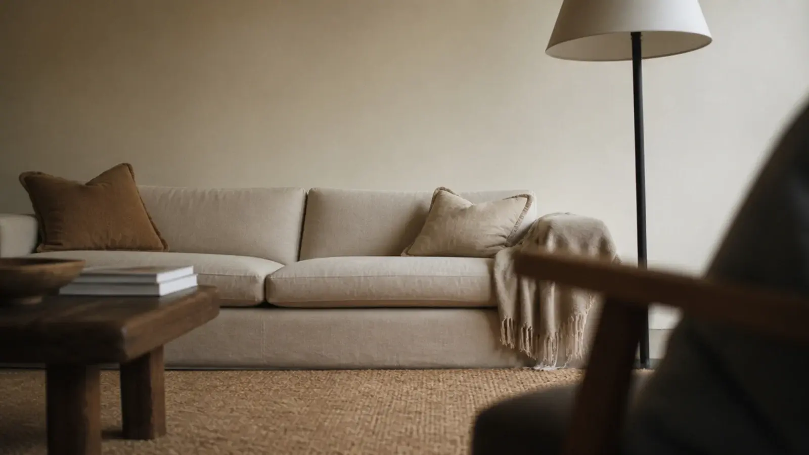 view of a bare sofa wall taken from a low armchair opposite