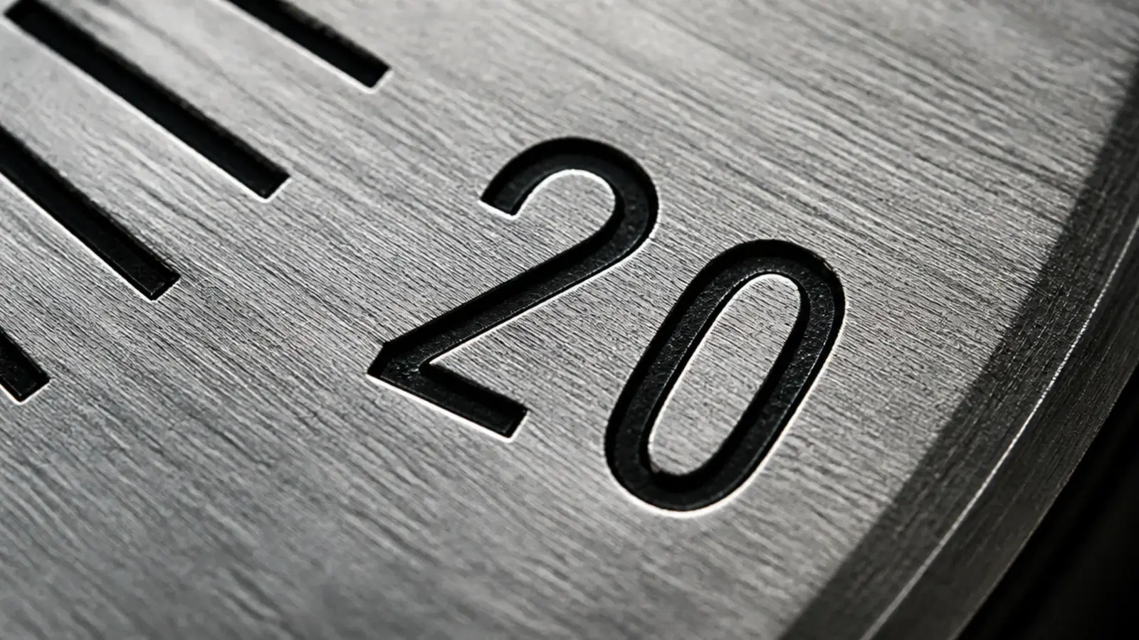 engraved numerals cut into a metal dial with filled black paint