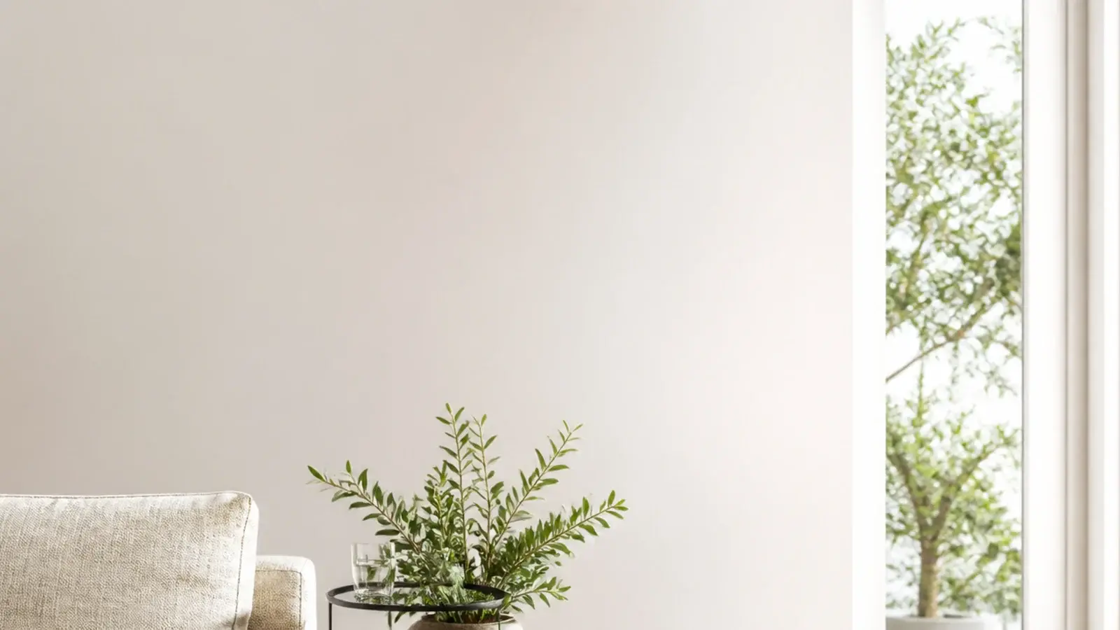 tall view of pale wooden flooring with a jute rug and linen sofa