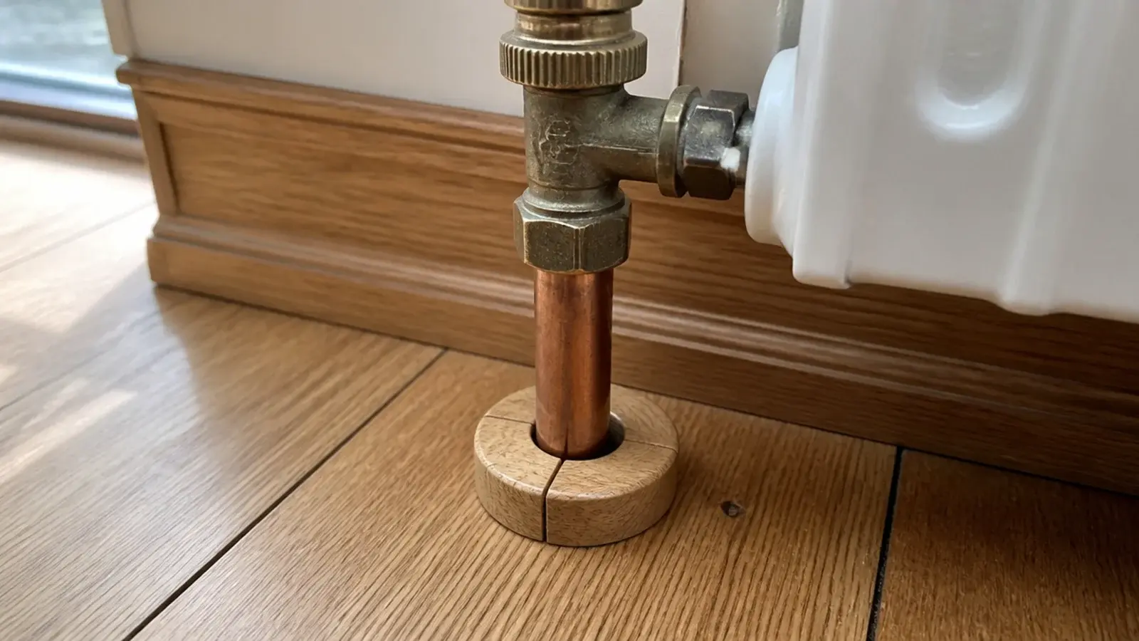 two part timber collar fitted neatly around a radiator pipe in floor