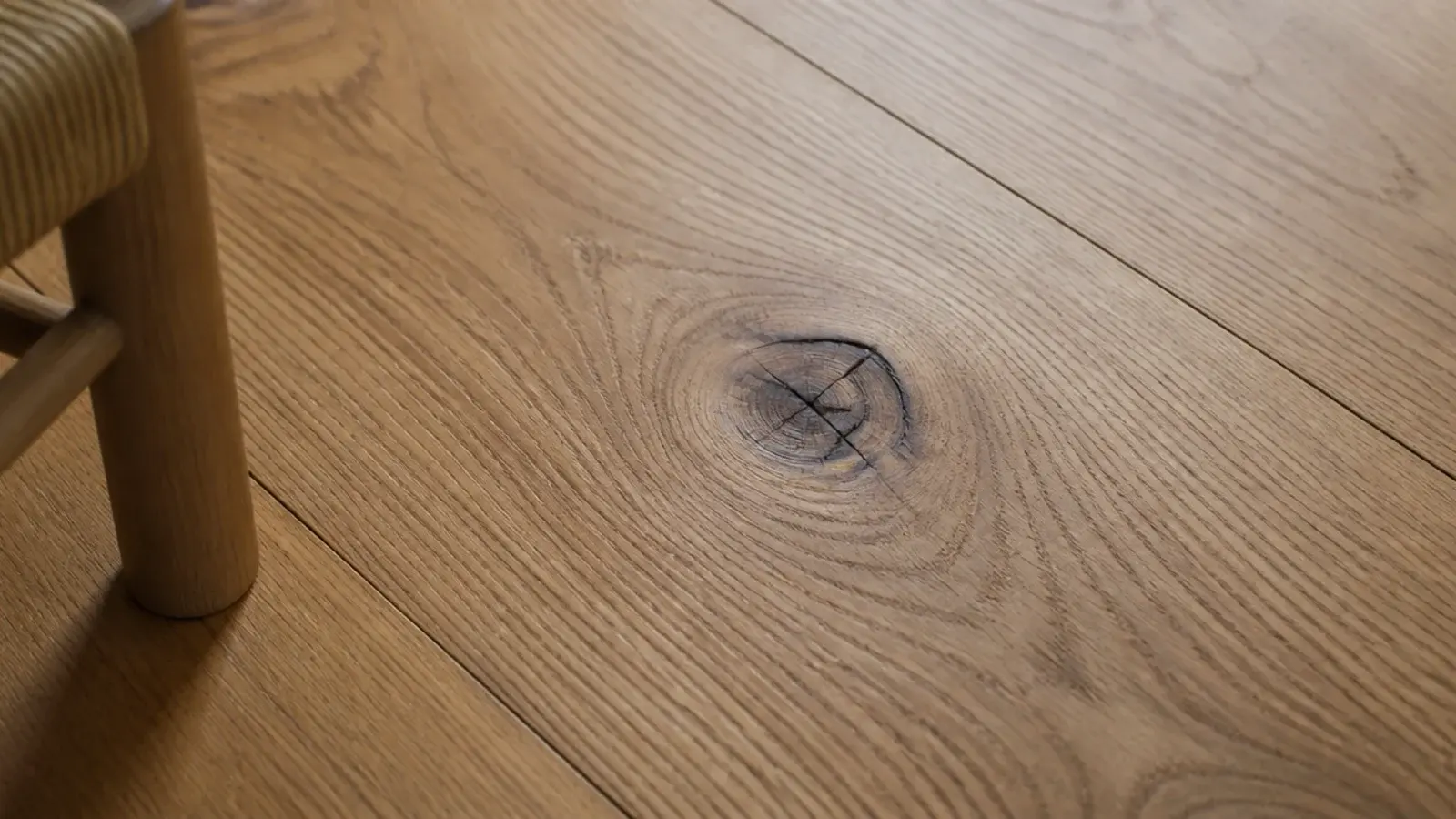 oak floorboard with a dark open knot left proud of the finish