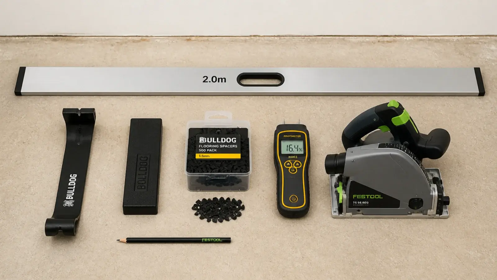 flooring tools laid out on a subfloor including pull bar and spacers