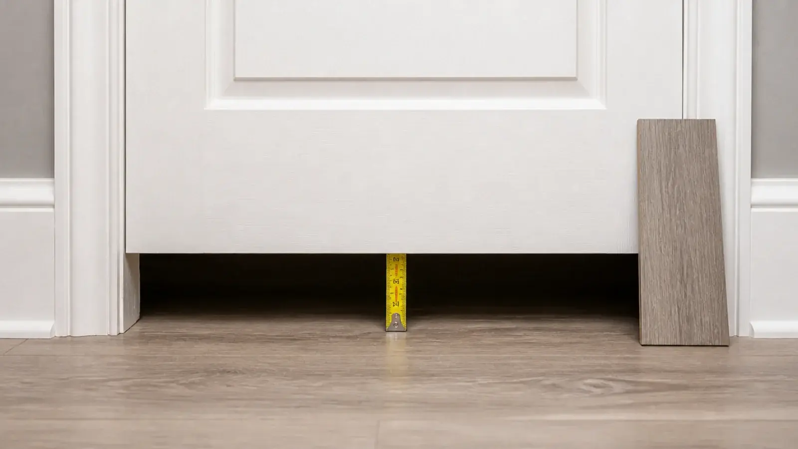 gap under a bedroom door measured with a tape before ordering planks