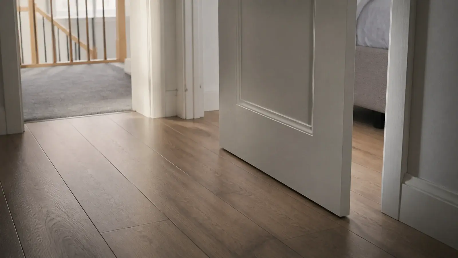 bedroom door opening cleanly over newly laid plank flooring