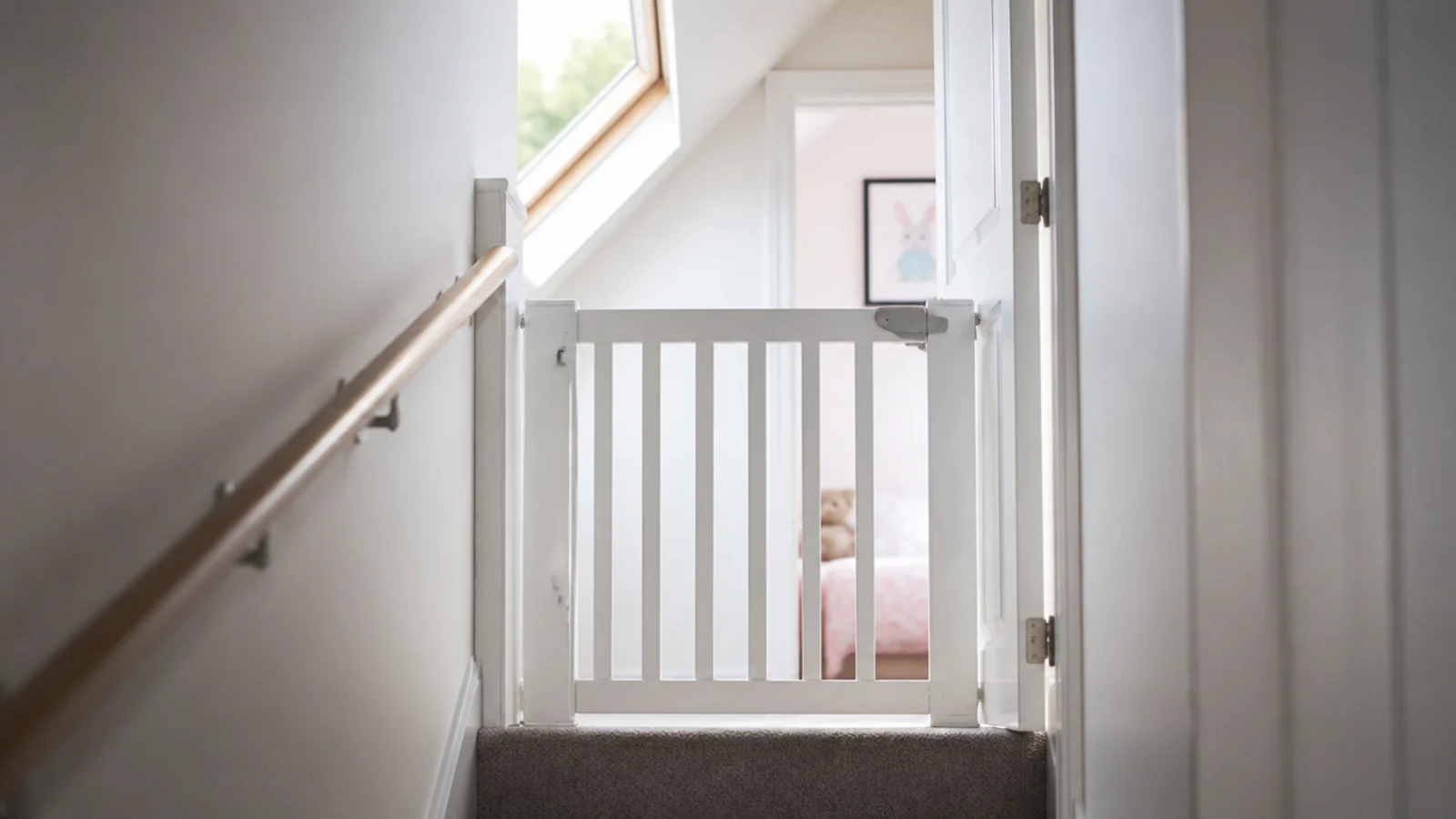 stair gate fitted at the head of a loft staircase outside a bedroom