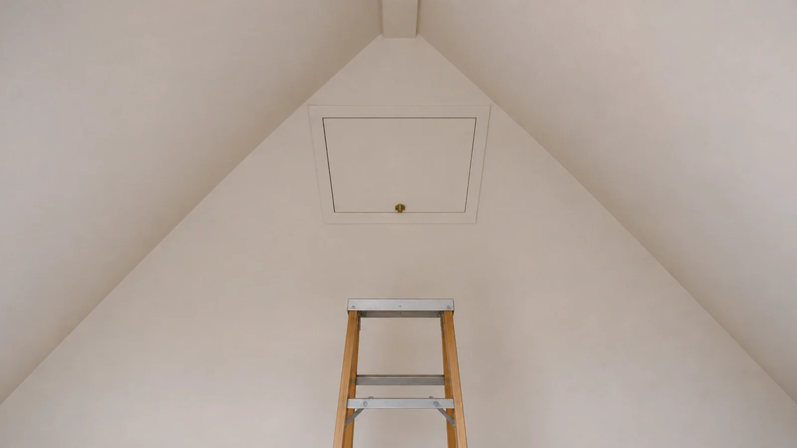 small painted access hatch set into a sloped attic bedroom ceiling