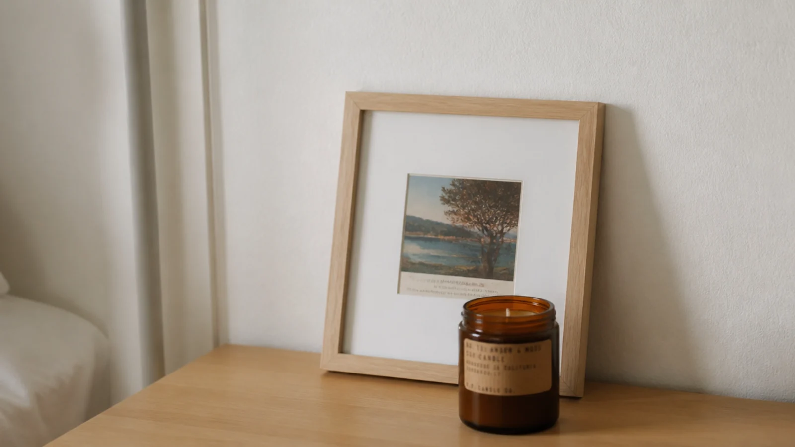 small postcard displayed in a plain frame leaning against a wall