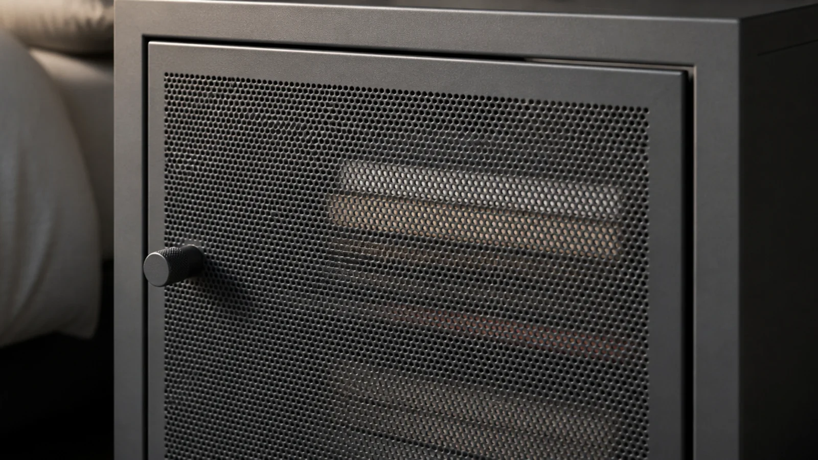 perforated steel cabinet door partly concealing books stacked inside