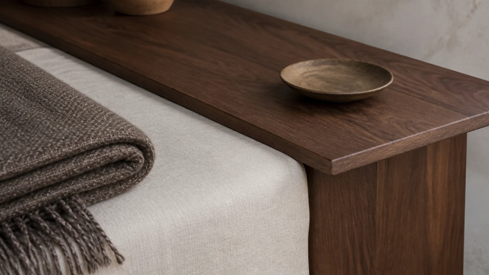 bedside table top sitting level with the edge of a made bed