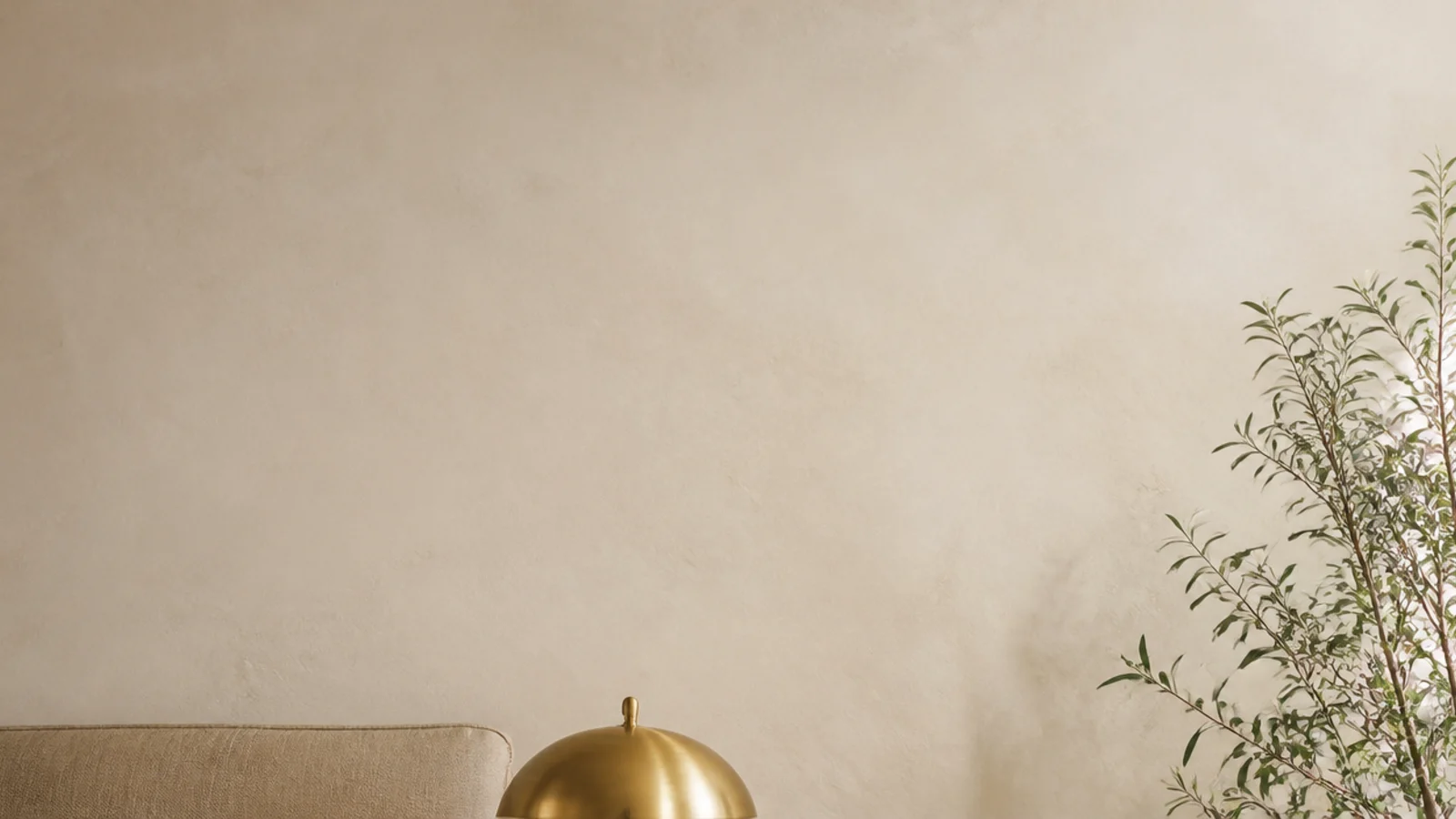 tall view of styled bedside table ideas with lamp book and trailing plant
