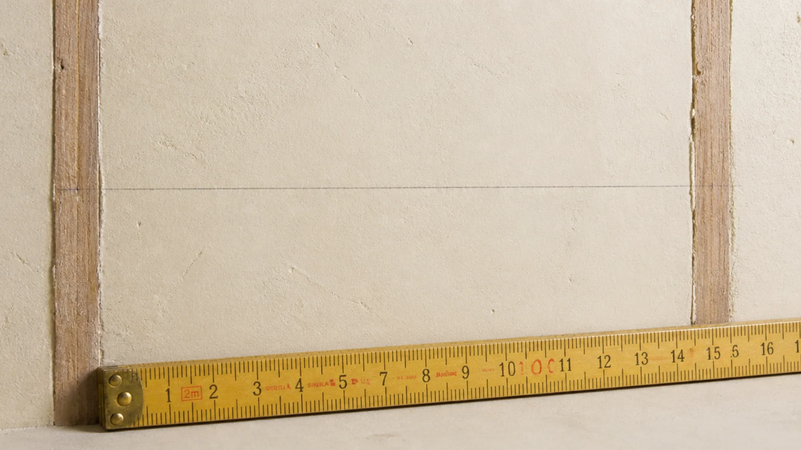 pencil line drawn between two marked stud positions on a wall