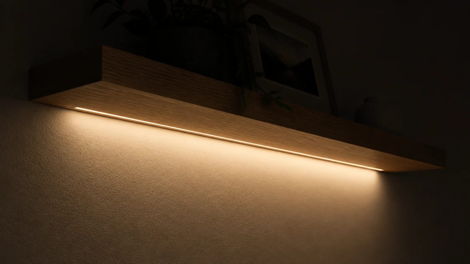 warm light glowing from beneath a floating bedside shelf at night
