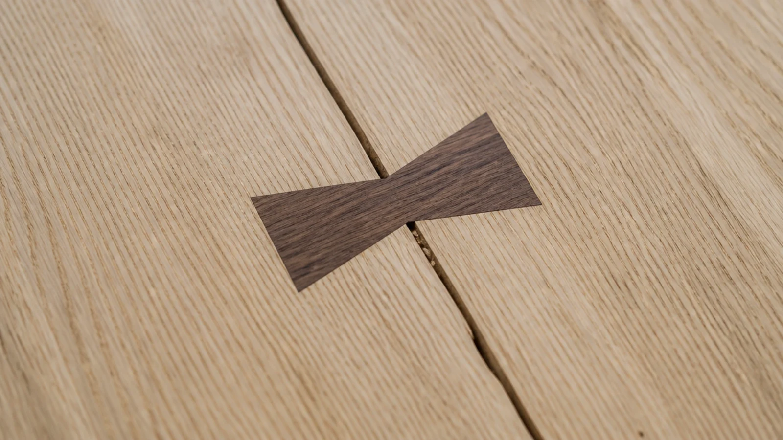 dark butterfly key inlaid across a split in a pale timber top