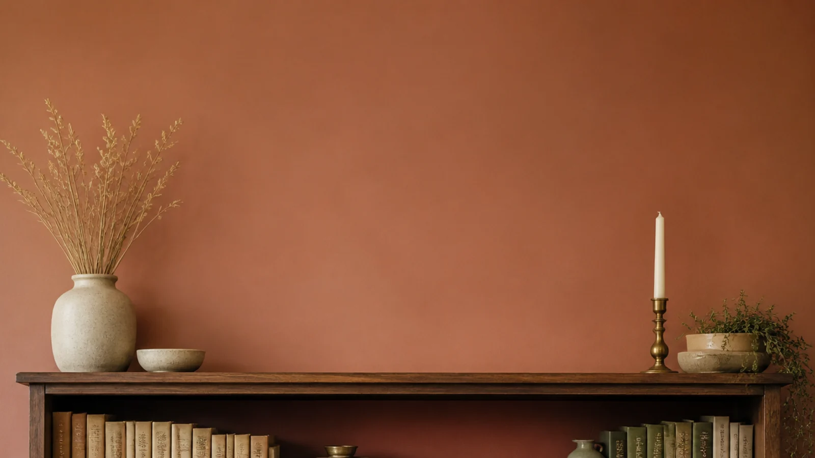 vertical colorful bookshelf styled with clay sage brass and layered pottery