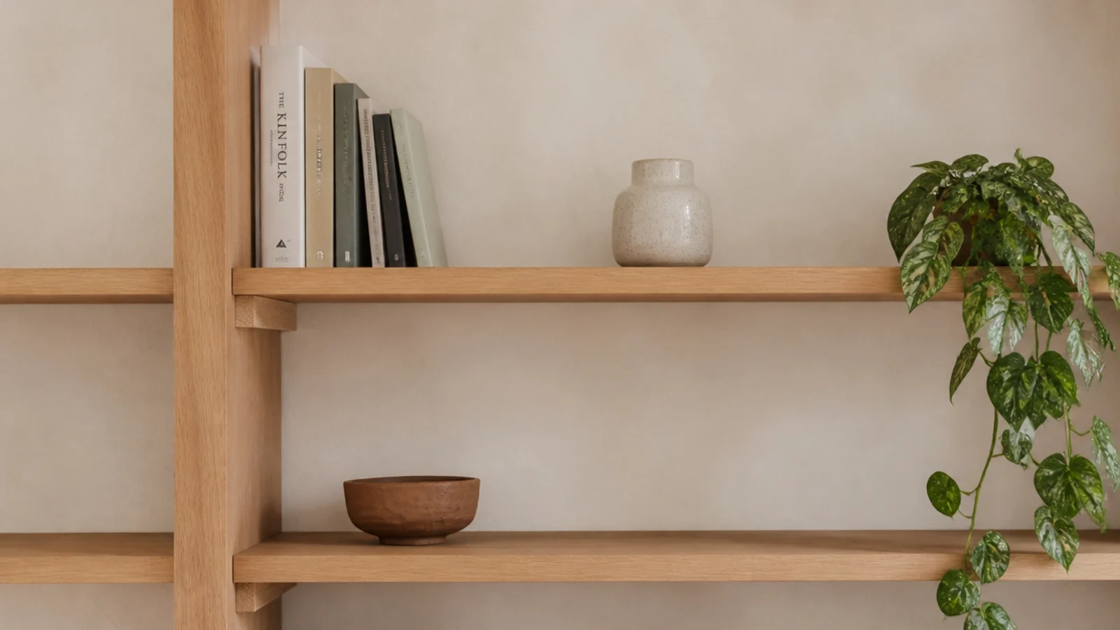 minimalist bookshelf styled with three objects wide gaps and pale oak boards