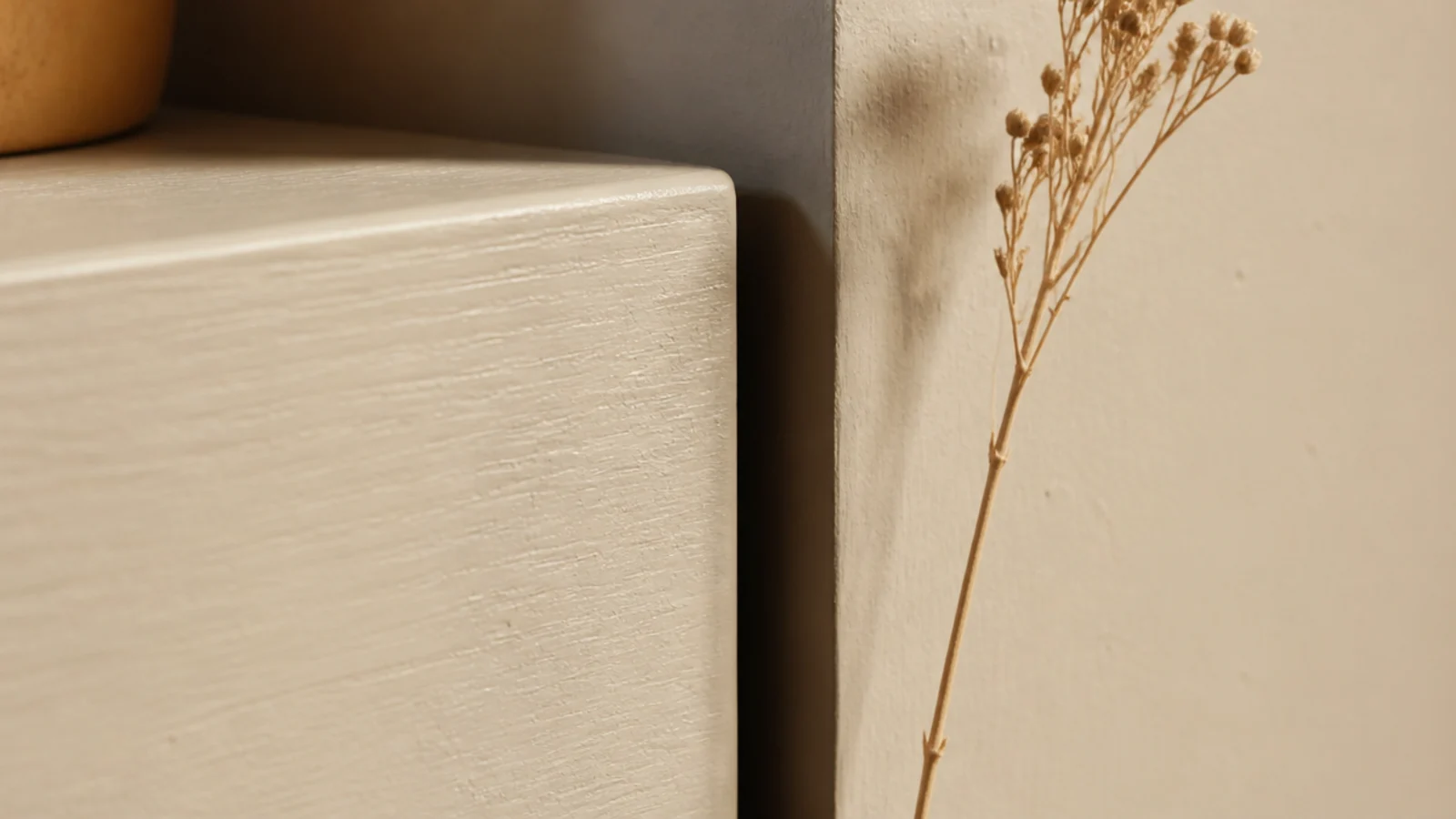deliberate shadow gap between a painted floating shelf end and the alcove wall