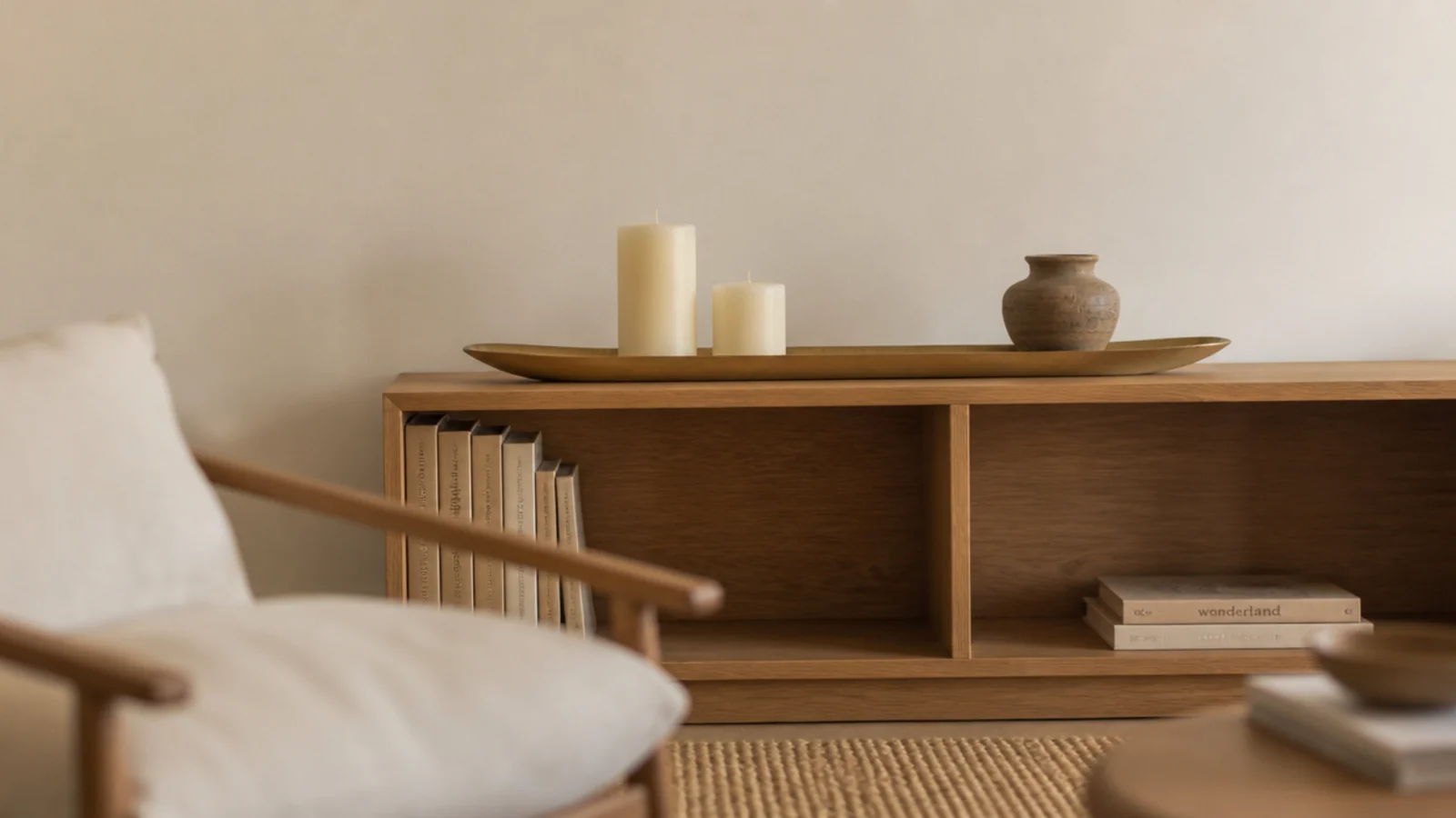 low bookcase top styled as a mantel with candles and clear wall above