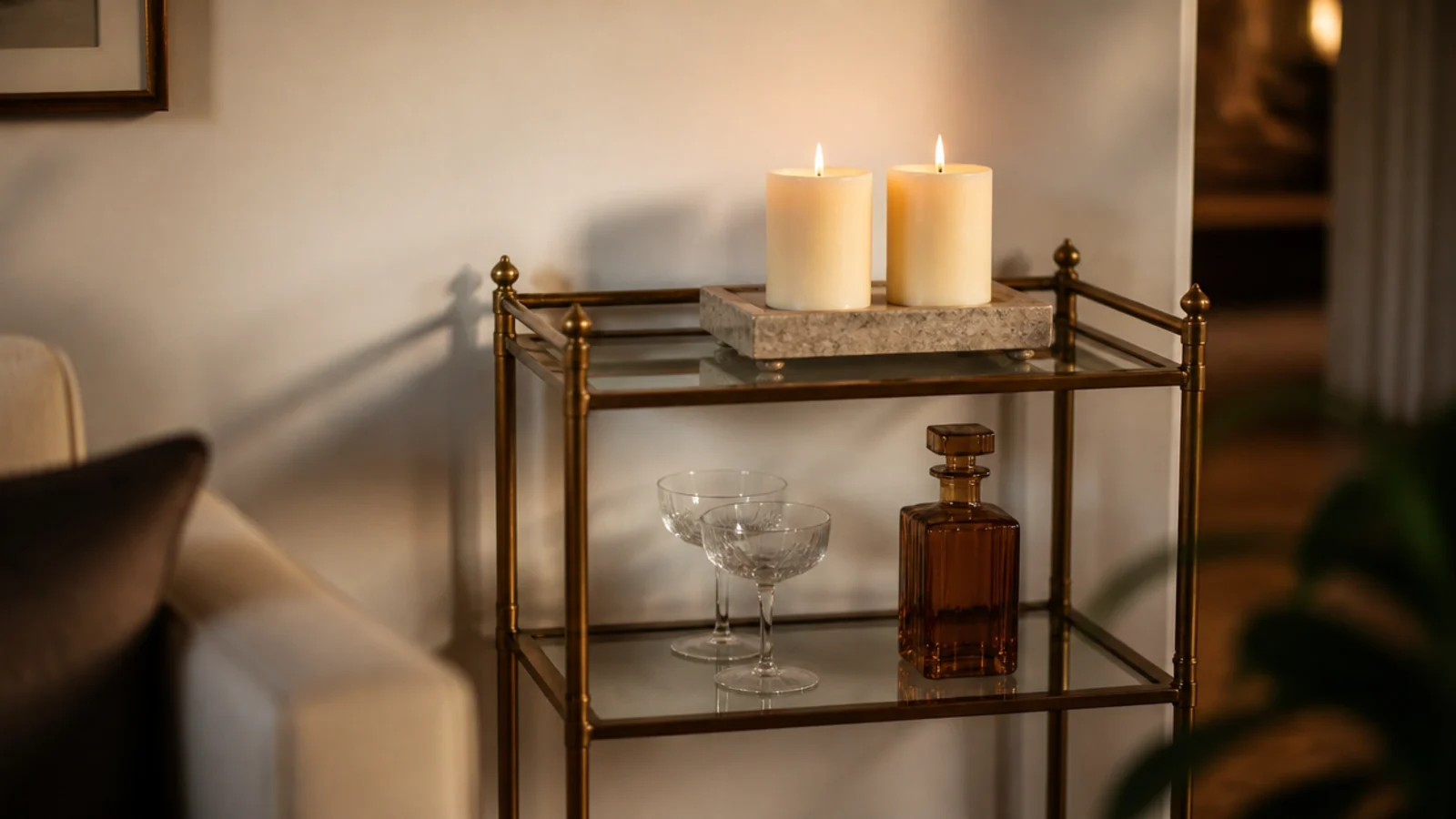 brass bar cart with a candle tray glasses and a small snuffer