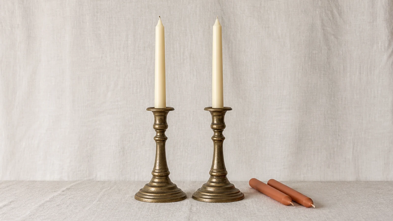 same brass holders shown with cream candles and with terracotta candles