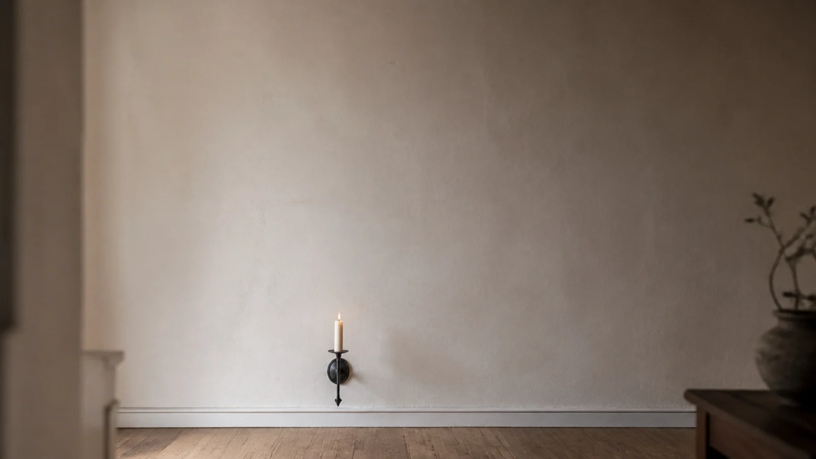 wall sconce with a tall empty span of plaster rising above the candle