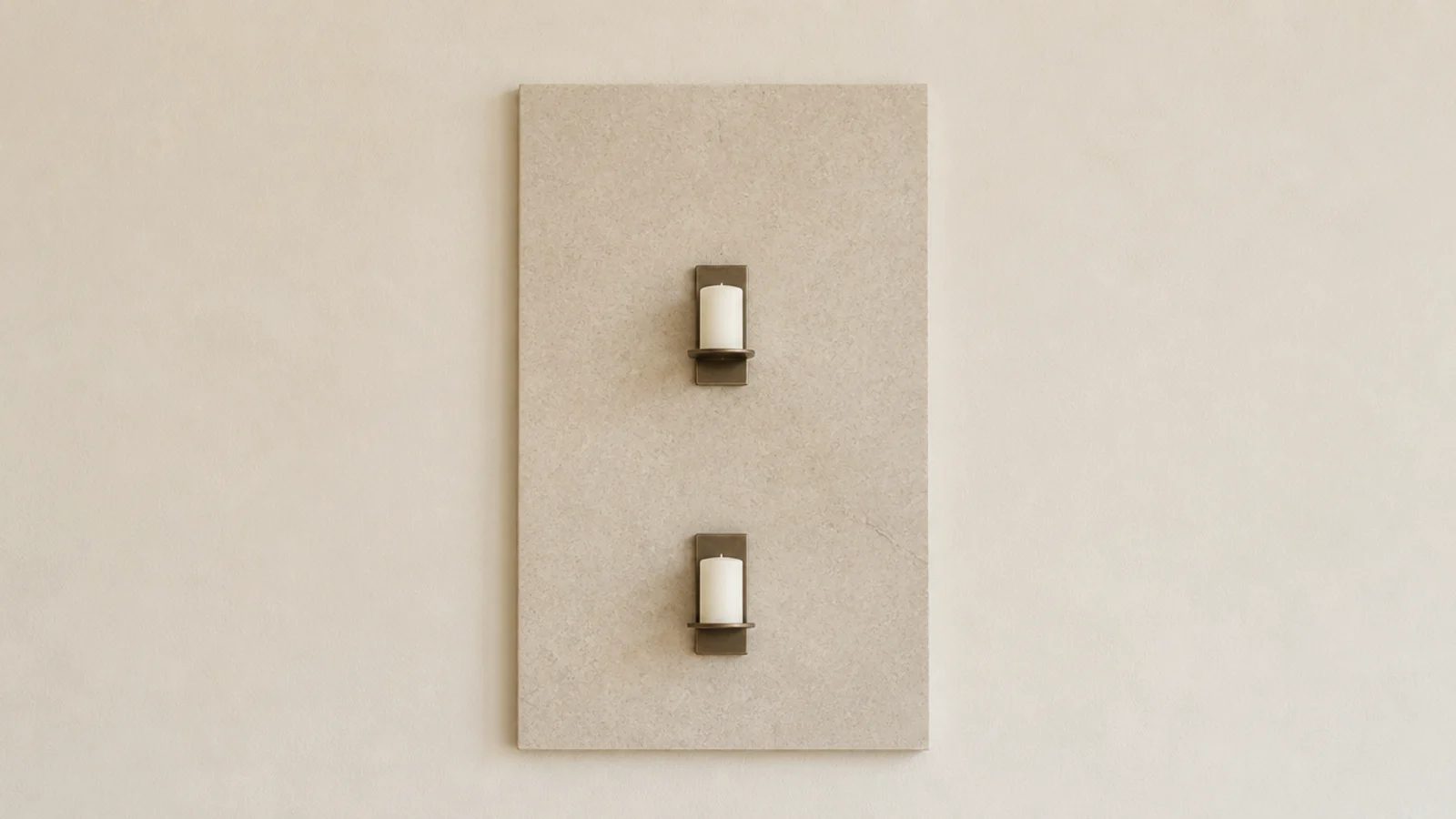 pale stone panel mounted behind two wall candles as a heat shield