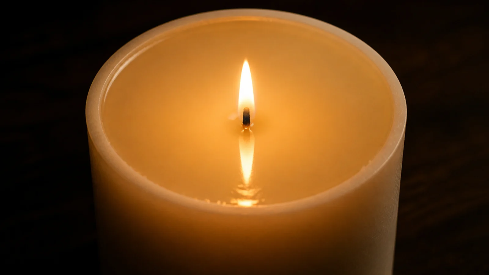wide pillar candle with melted wax reaching its full outer edge
