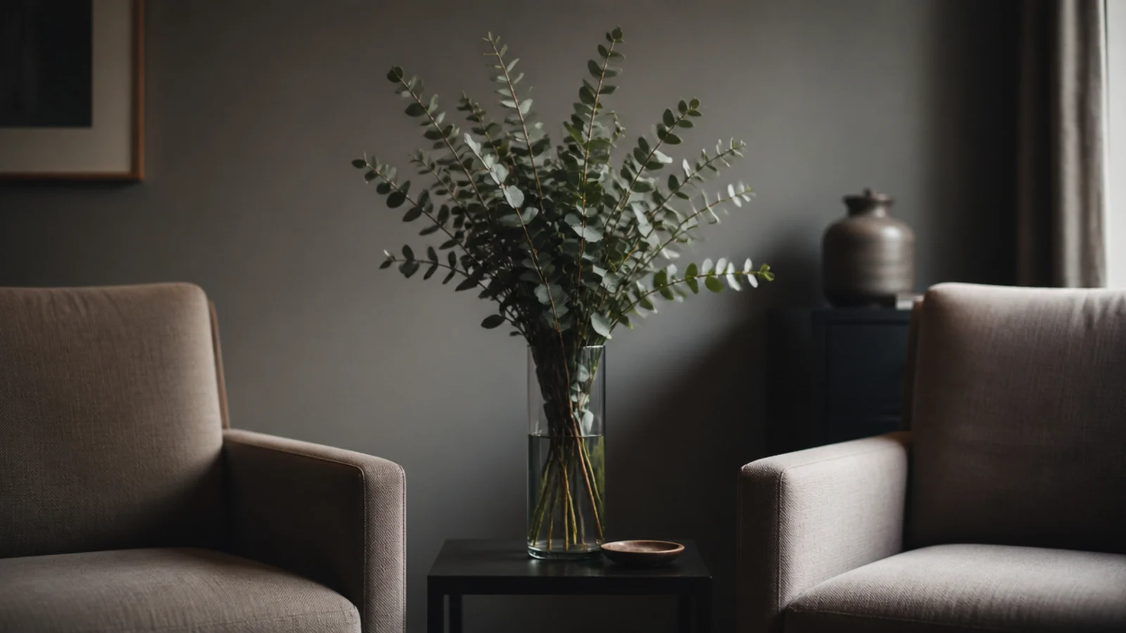 tall vase of stems blocking the view between two seats in a room