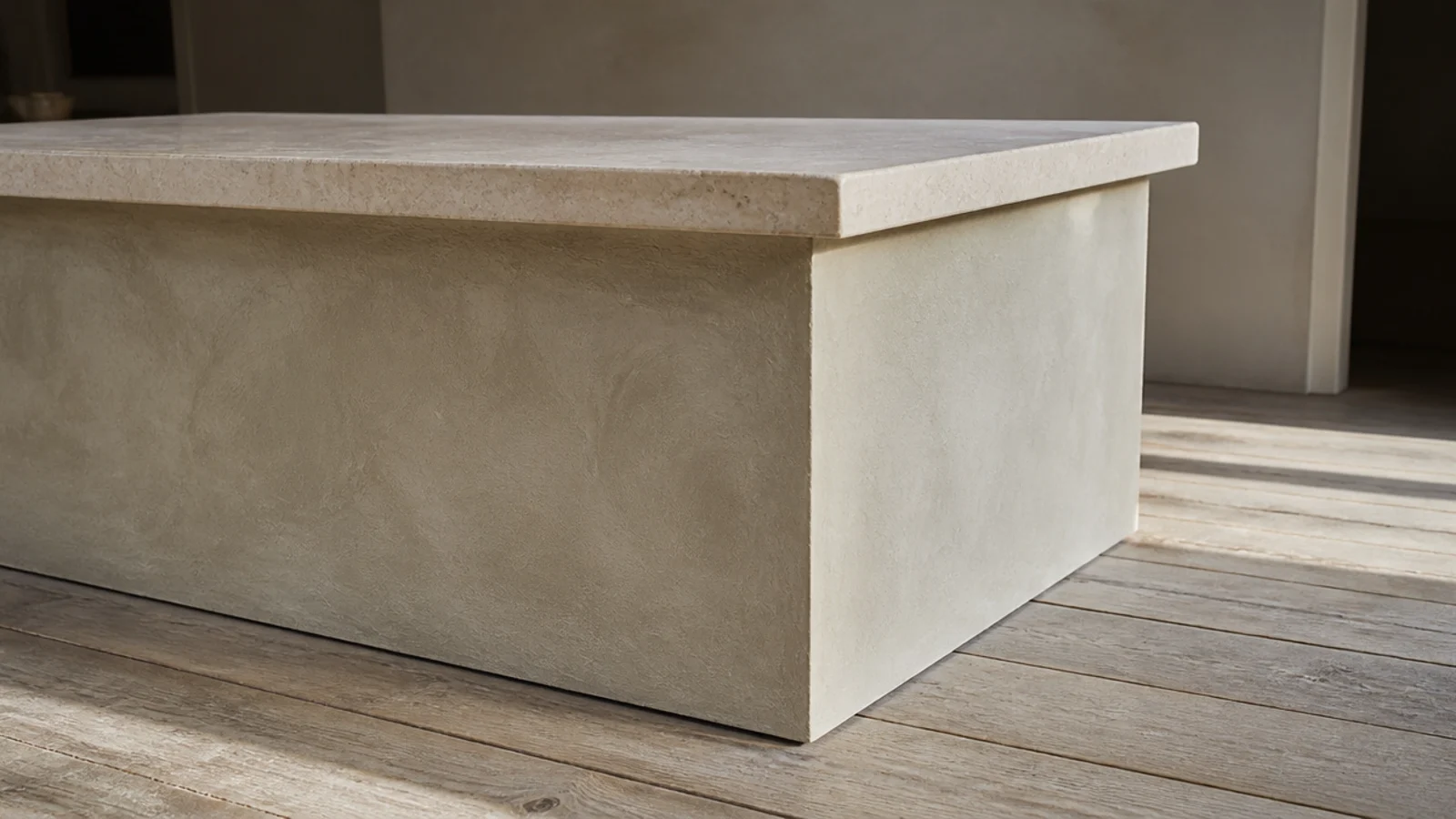 textured plaster table base beneath a plain honed stone slab top