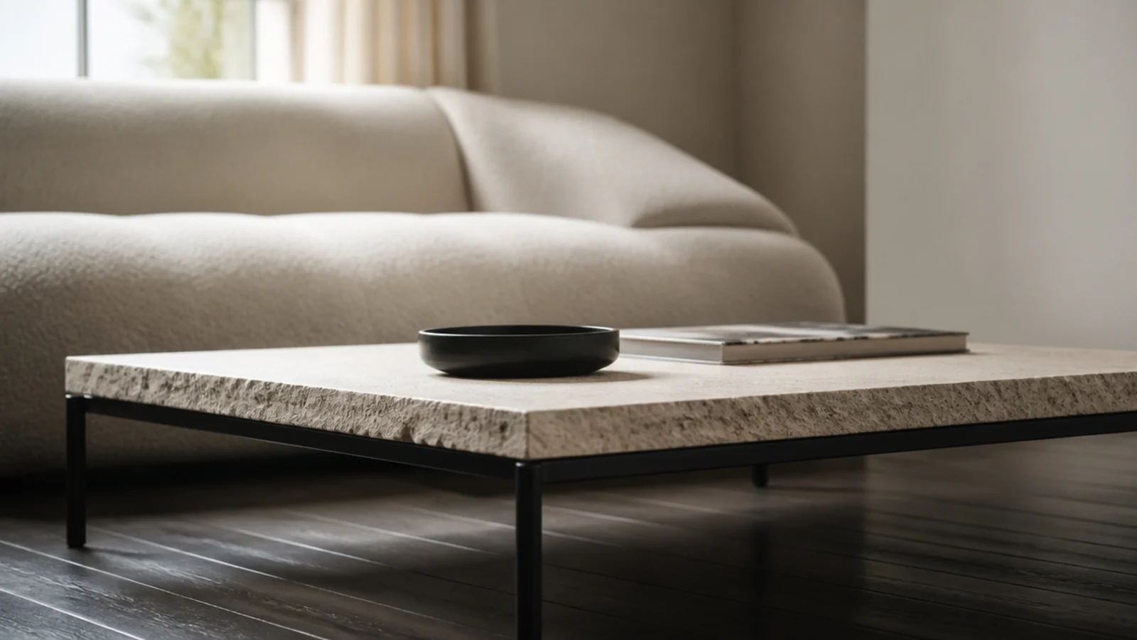 slim dark metal base carrying a thick pale stone table top