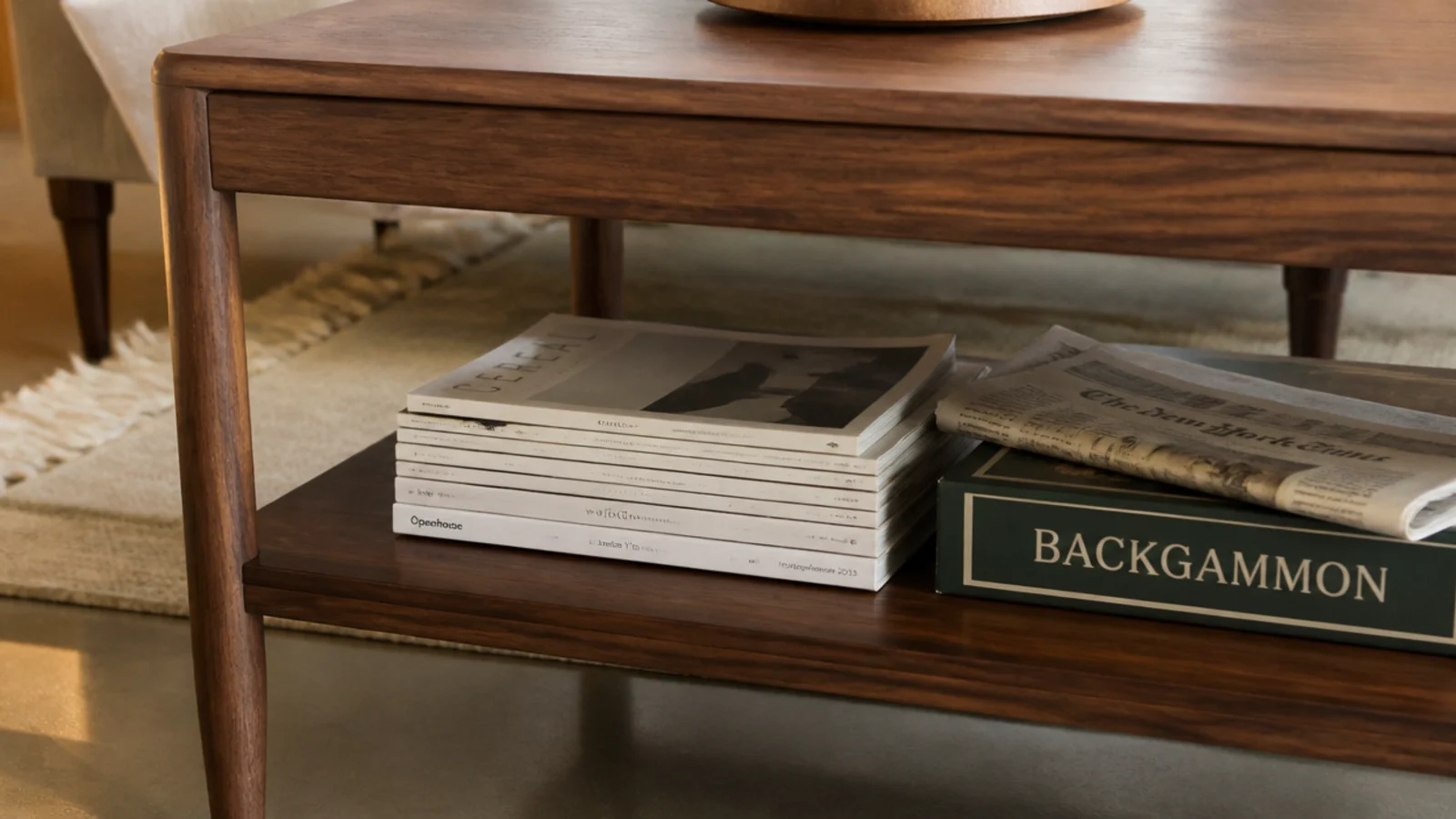 lower table shelf holding stacked magazines and a folded newspaper