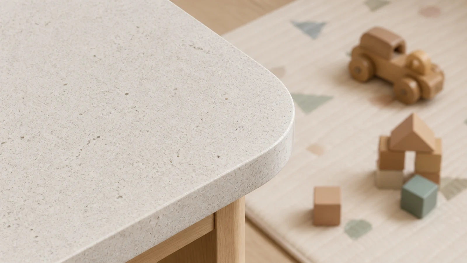 gently radiused corner on a stone table beside a childrens play mat