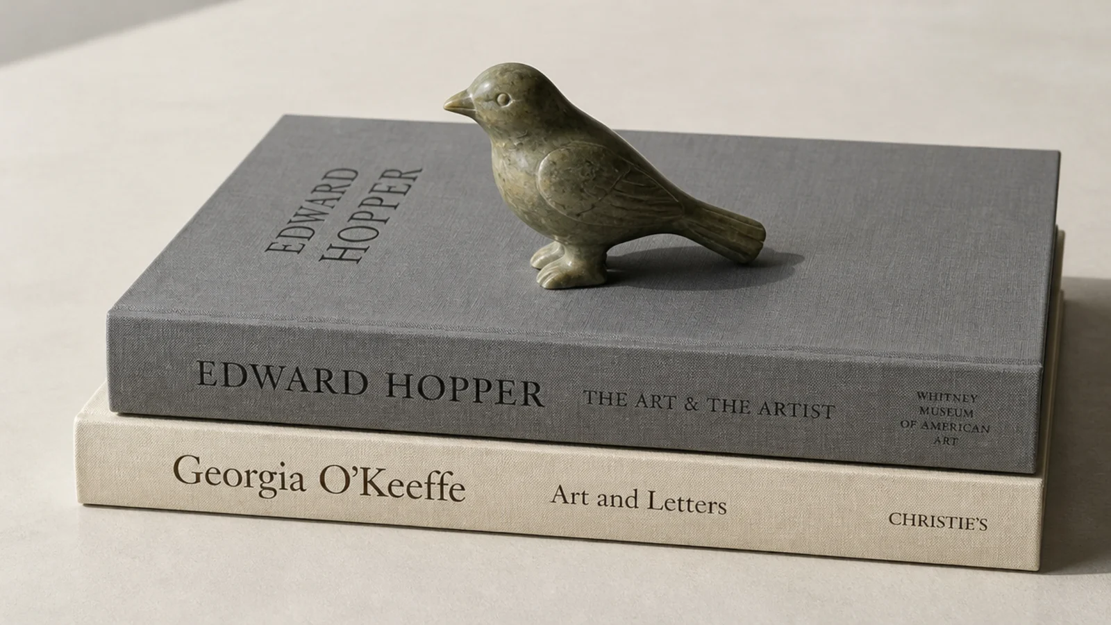 small carved object standing on a flat stack of two large books